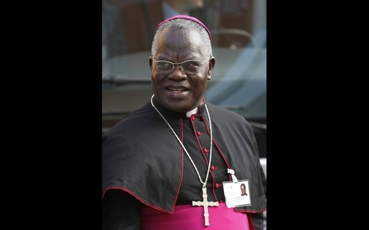 Laurent Monsengwo Pasinya smiling while wearing eyeglasses, cross necklace and black cassock