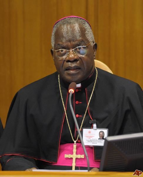 Laurent Monsengwo Pasinya giving a speech while wearing eyeglasses, cross necklace, black cassock and mitre