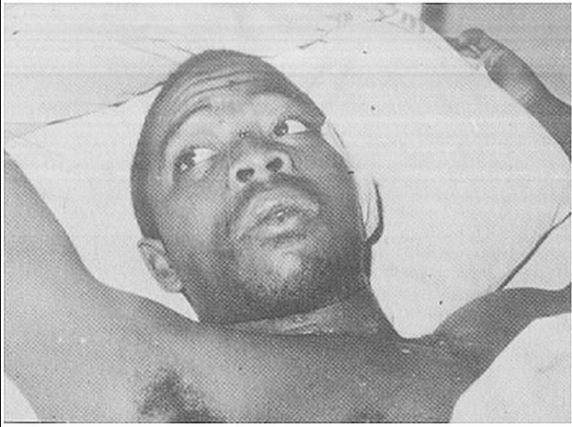 Lawrence Anini looking at something while lying in the bed
