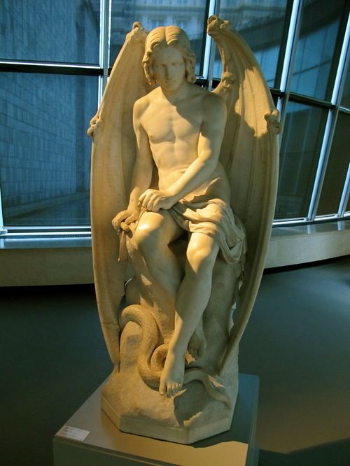 The sculpture of the Fallen Angel Lucifer by Joseph Geefs. Lucifer is sitting on a rock, covered with folded wings and his upper torso, arms, and legs are naked.
