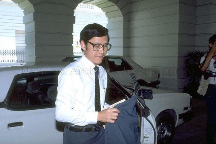 Lee Yock Suan wearing eyeglasses, white long sleeves, and a black tie.