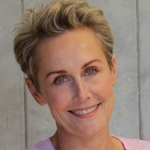 Lenore Smith smiling with a short hair and wearing a pink blouse