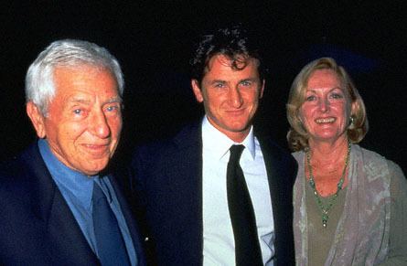 Leo Penn, Sean Penn, and Eileen Ryan are smiling while Leo is wearing a black coat, blue long sleeves, and dark blue necktie