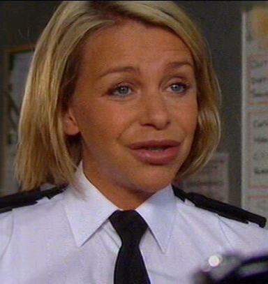 Leslie Ash talking with someone while wearing a white sleeve with a black necktie