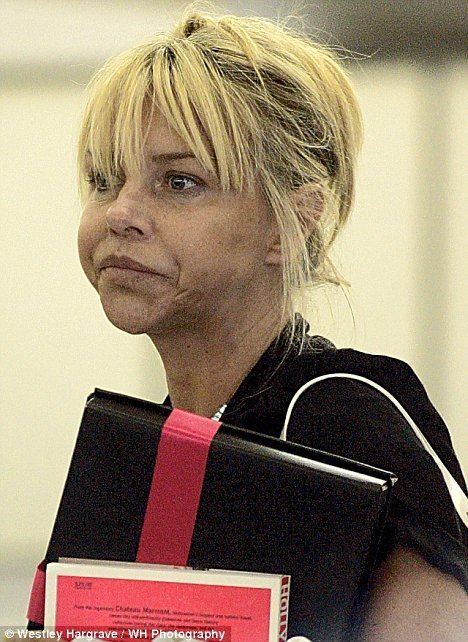 Leslie Ash looks emotional while holding a books and wearing a black shirt