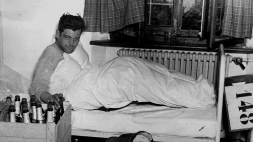 Lewis Nixon III lying on the bed while holding a bottle