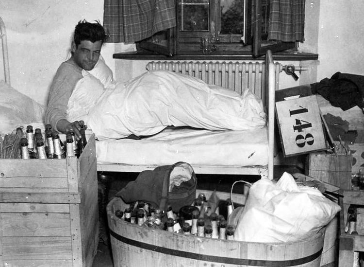 Lewis Nixon III lying on the bed while holding a bottle