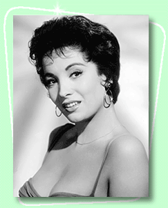 Linda Cristal smiling while wearing a sexy sleeveless top, earrings, and necklace