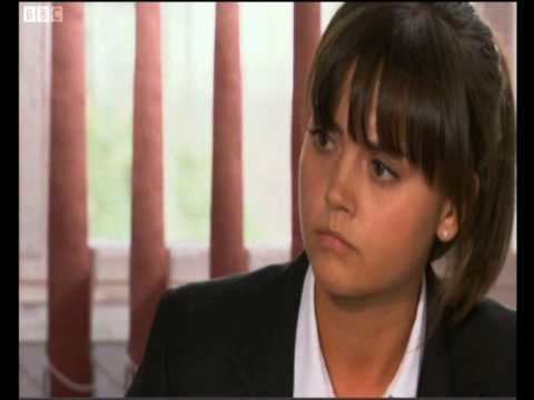 Jenna Coleman as Lindsay James, looking at something while wearing a black coat and white long sleeves in a scene from the 2006 tv series, Waterloo Road