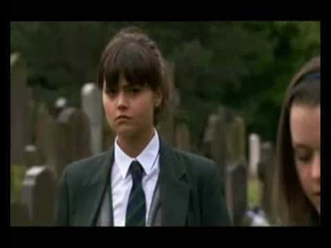Jenna Coleman as Lindsay James, wearing a black coat, gray vest, white long sleeves, and necktie in a scene from the 2006 tv series, Waterloo Road