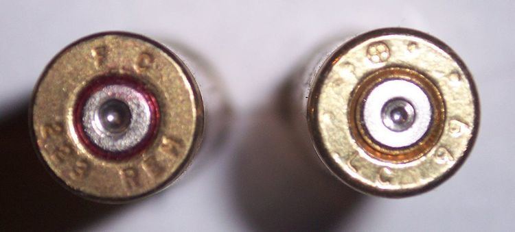 Two 223 Headstamps. The left cartridge's headstamp says "FC 223 REM" which means that it was made by Federal Cartridge Co. and it is in the caliber ".223 Remington". The cartridge on the right has a headstamp that says "LC 99" with a symbol that consists of a cross in a circle. This cartridge was made in 1999 by the Lake City Army Ammunition Plant, in Independence, Missouri, USA. The symbol on this headstamp means it meets NATO specifications.