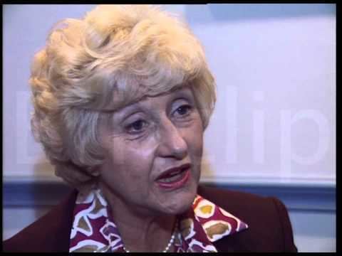 Liz Fraser during an interview, with short blonde hair and wearing a red blouse.