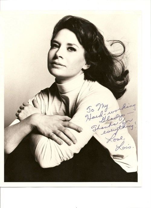 Portrait of Lois Nettleton with a letter autograph on the bottom right  while she is wearing a turtleneck blouse