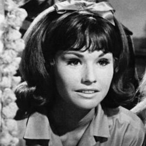 Lori Saunders smiling while wearing headband and blouse