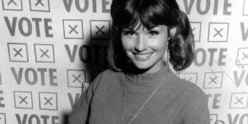 Lori Saunders smiling and wearing turtle neck blouse