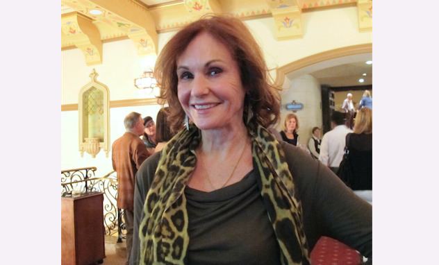 Lori Saunders smiling while wearing animal print shawl and gray long sleeves