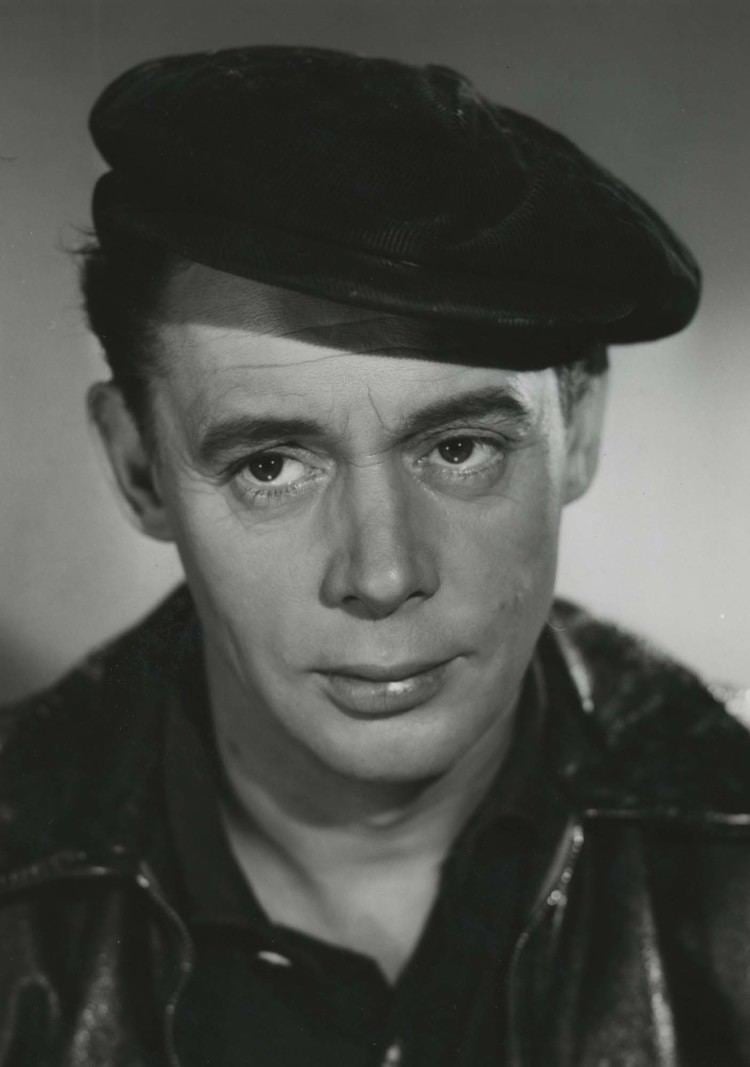 Louis Miehe-Renard wearing a black beret, black jacket, and black polo