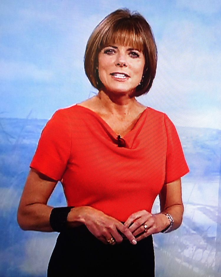 Louise Lear wearing red blouse and black skirt