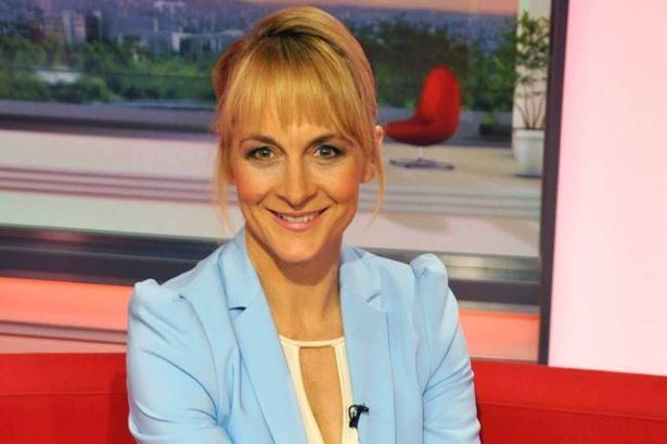 Louise Minchin smiling while wearing a blue blazer and white inner top