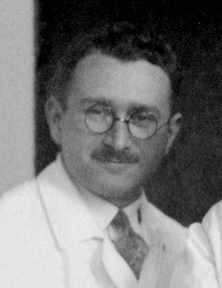 Ludwig Guttmann wearing eyeglasses and a white suit.