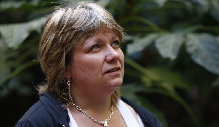 Lydia Gouardo wearing a black jacket, white top, earrings, and necklace