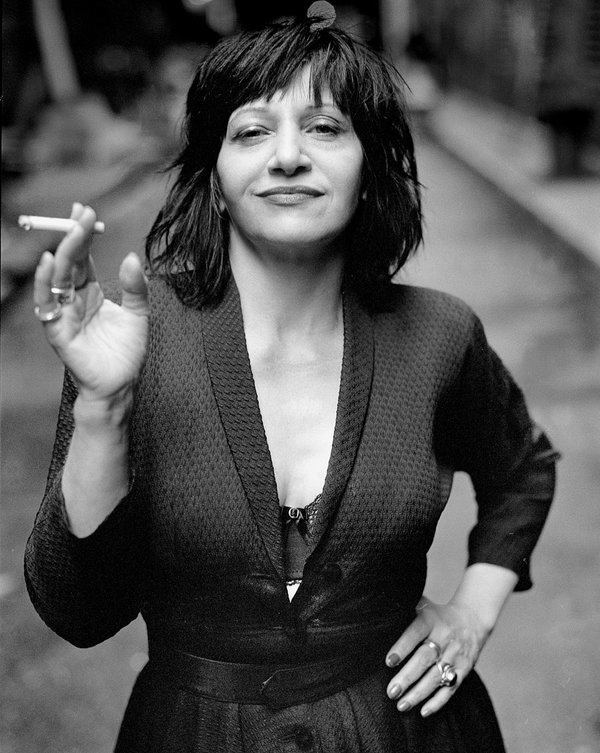 Lydia Lunch wearing a dress while holding a cigarette