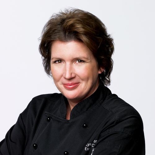 Lynn Crawford smiling and wearing black chef's uniform
