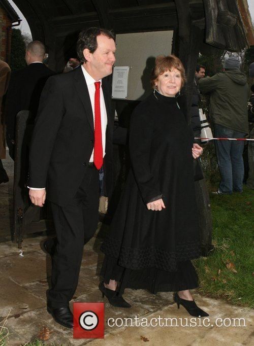 Madelaine Newton wearing a black dress while Kevin Whately wearing a black coat, white long sleeves, a red necktie, and black pants