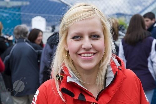 Madeleine Dupont smiling with blonde straight hair while wearing a red and black jacket