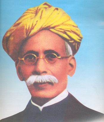 Madhusudan Das with mustache while wearing a yellow turban, eyeglasses, and black long sleeves