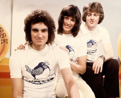 Mick Robertson, Susan Stranks and Tony Bastable smiling and wearing white shirts on the set of 1968 TV show Magpie.
