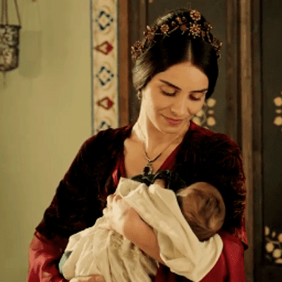 Scene from "Muhtesem Yuzyi" in which Meryem Uzerli carrying a baby and plays role of Mahidevran