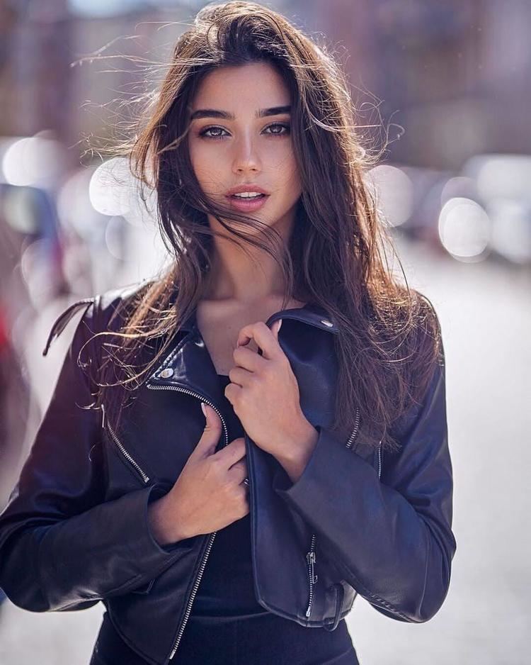 Maja Strojek posing with her mouth half-open while wearing a black leather jacket and black inner blouse