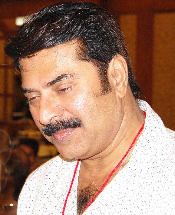 Mammootty with a tight-lipped smile and wearing a black and white polo