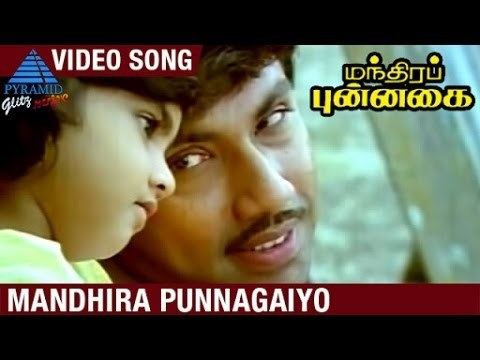 Sathyaraj smiling while looking at the toddler in a movie scene from Mandhira Punnagai (1986 film)