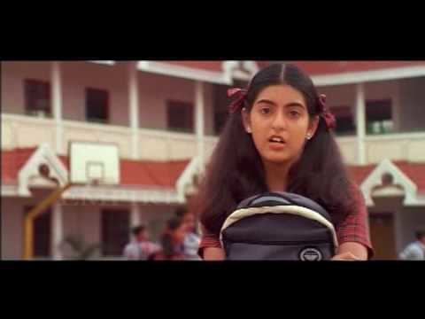Amrita Prakash carrying her bag and wearing a red checkered blouse in a scene from the 2004 Malayalam film, Manjupoloru Penkutti