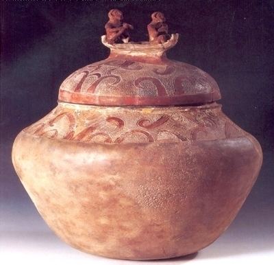 A Manunggul Jar with two prominent figures at the top handle of its cover.