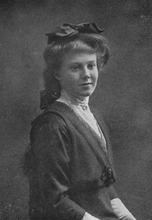 Margaret Carnegie Miller's tight-lipped smile while wearing a long sleeve dress and a ribbon on her hair