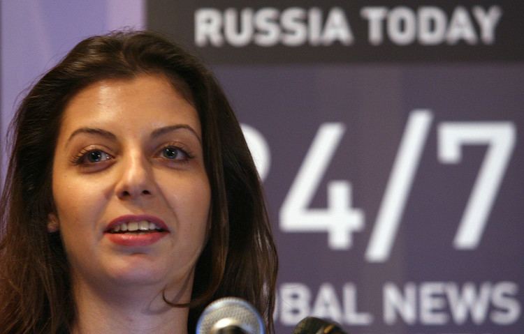 Margarita Simonyan is smiling while talking in front of a microphone.