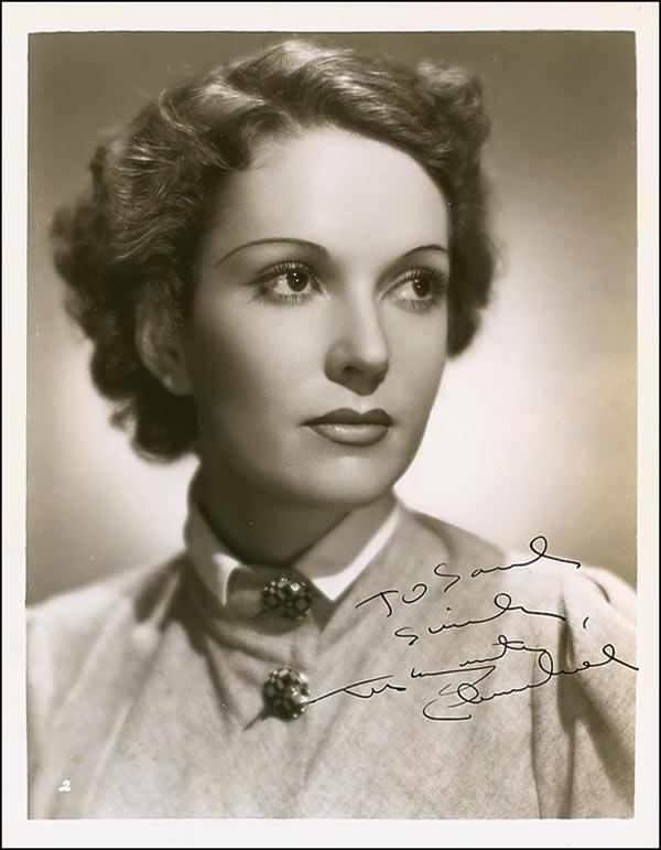 In a Taupe vintage effect, Marguerite Churchill is serious, has short black hair, gray blouse with a collar and large buttons in front is her signature.