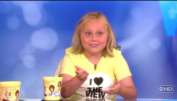 Maria Lark in her interview on The View wearing a yellow printed shirt having two cups on her table | Source: www.buddytv.com
