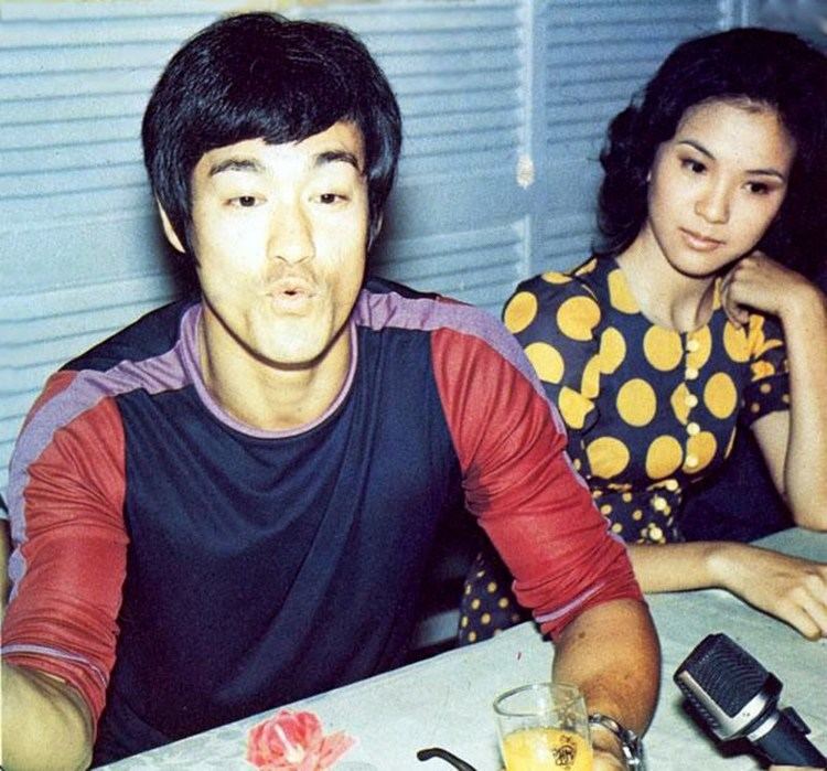 Maria Yi wearing black and yellow polka dots dress and Bruce Lee wearing a long sleeves shirt