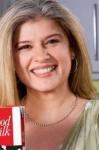 Marina Khan smiling while wearing a green blouse and necklace