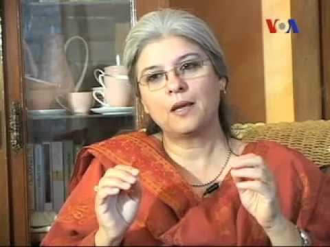 Marina Khan during her interview wearing an orange dress, eyeglasses, and some pieces of jewelry