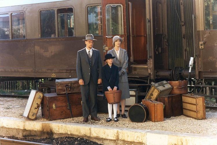 Julian Sands, Anna Galiena, and Nina Schweser standing next to the train in a movie scene from the 1994 film Mario and the Magician