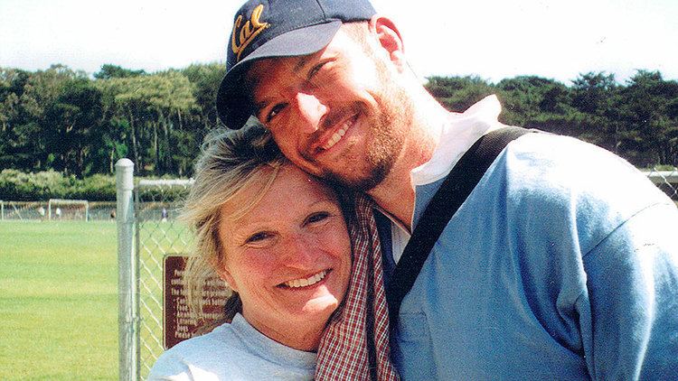 Mark Bingham smiling while wearing a black cap and blue polo shirt  with his mother, Alice Hoagland
