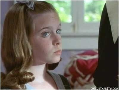 Marley McClean looking at someone while wearing a black and white blouse and a ribbon clipped on her hair