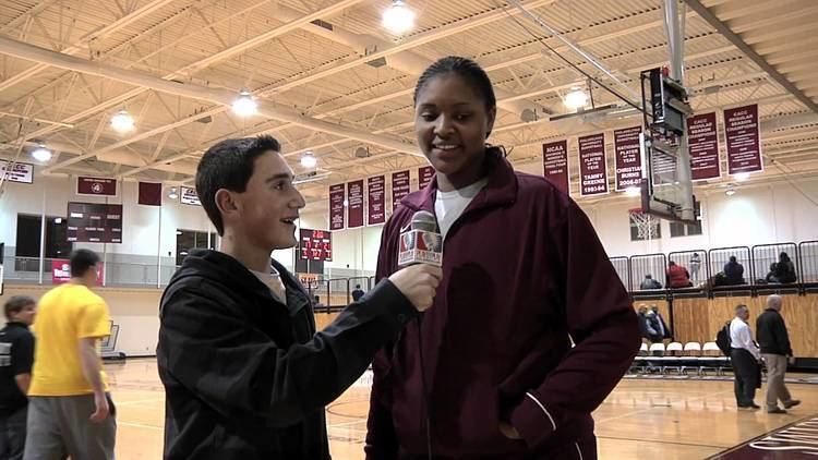Marvadene Anderson being interviewed inside the gym while wearing a violet jacket