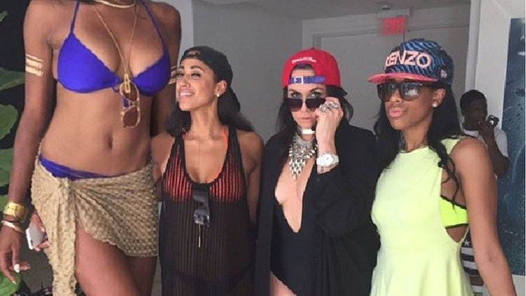 Marvadene Anderson wearing a blue swimsuit with the three women beside her