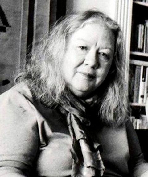 Mary Thom inside a library wearing scarf.